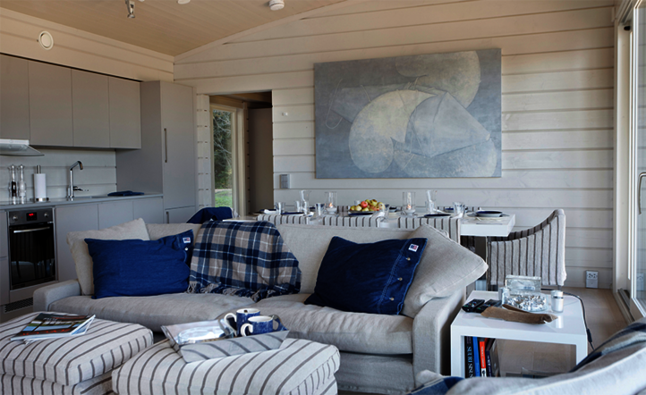 Living area of a Finnish weekend get-away house with white coated timber panelling.