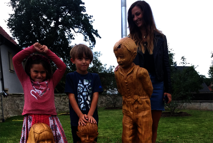 Theresia Hofmann y sus hijos con sus esculturas de madera delante