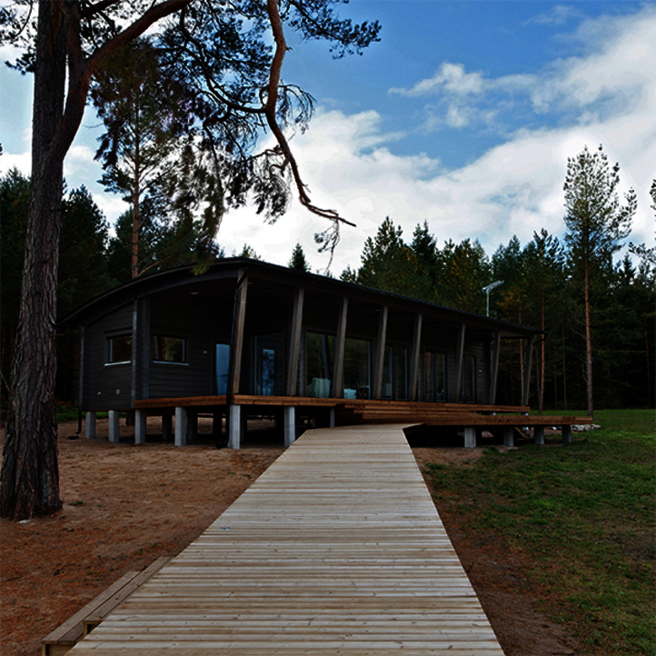 Cabaña con pasarela junto al lago en Finlandia; la madera está acabada con productos Osmo