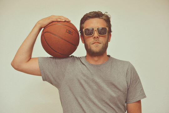 A man wearing a Stadtholz eyeglass frames made of solid wood treated with Osmo Polyx®-Oil