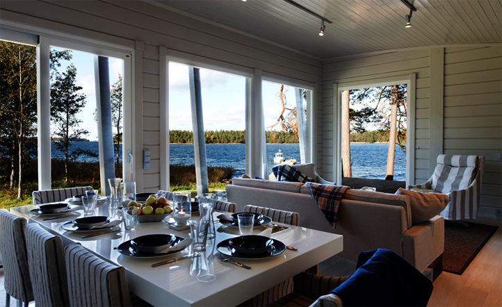 Intérieur - la salle à manger de la maison de campagne en Finlande traitée avec Osmo. Ambiance tout en blanc avec vue sur le lac.
