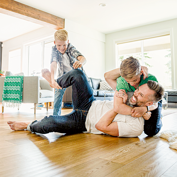 Un padre jugando en el salón con sus dos hijos